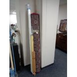 A large red floral woolen rug together with three window blinds and artist easel