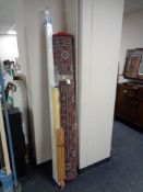 A large red floral woolen rug together with three window blinds and artist easel