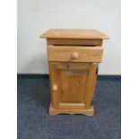 A stripped pine bedside cabinet