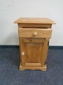 A stripped pine bedside cabinet
