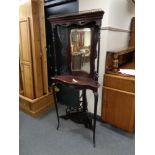 An antique mahogany corner mirrored stand on cabriole legs with carved fret work