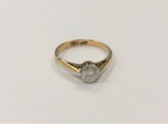 An 18ct gold and platinum diamond solitaire ring, the brilliant cut stone weighing approximately 0.