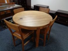 A Laura Ashley circular oak dining table and four leather seated chairs