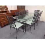 A glass-topped and wrought iron based dining table,