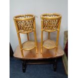 A copper finish coffee table and a pair of bamboo and wicker plant stands