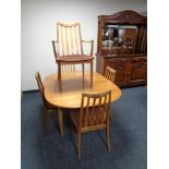 A 20th century teak G Plan extending dining table and five rail back chairs