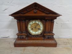 An antique mahogany and pine Continental mantel clock with brass and enamelled dial