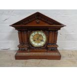 An antique mahogany and pine Continental mantel clock with brass and enamelled dial