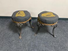 A pair of vintage cast iron bar stools on painted legs upholstered in Guinness fabric