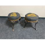 A pair of vintage cast iron bar stools on painted legs upholstered in Guinness fabric