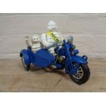A metal Michelin man on bike with sidecar