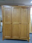 A contemporary oak triple-door wardrobe.