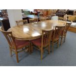 An oval twin pedestal rubberwood dining table with internal leaf and six high back chairs