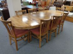 An oval twin pedestal rubberwood dining table with internal leaf and six high back chairs
