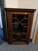 A Georgian oak hanging corner cabinet with astragal glazed door