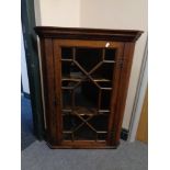 A Georgian oak hanging corner cabinet with astragal glazed door