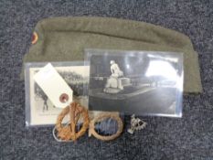 A twentieth century German cloth cap together with three military badges and three WWI postcards