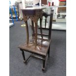 A carved oak hall chair and a painted plant stand
