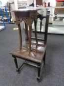 A carved oak hall chair and a painted plant stand