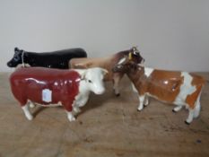 Four Beswick figures - Cows (a/f)