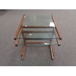 A teak glass topped table fitted with table beneath