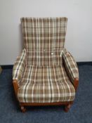 A mid 20th century teak framed rocking chair in brown tartan fabric