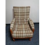 A mid 20th century teak framed rocking chair in brown tartan fabric