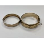 A vintage rolled gold bangle together with a white metal bangle with textured decoration.