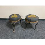 A pair of vintage cast iron bar stools on painted legs upholstered in Guinness fabric