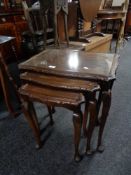 A nest of three mahogany and glass topped tables