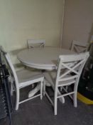 A circular pine kitchen table and four chairs