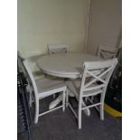 A circular pine kitchen table and four chairs