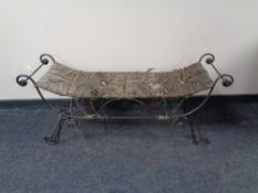 A wrought iron and rush seated window seat
