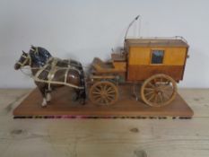 A hand built wooden cart with two china horses on stand