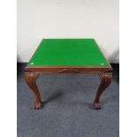 An Edwardian baize topped card table on claw and ball feet