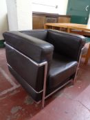 A brown leather and metal framed armchair