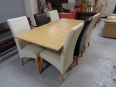 A contemporary oak effect extending dining table together with six high backed leather chairs (four