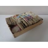 A box of a quantity of assorted tea and sweet cigarette cards together with two English crowns