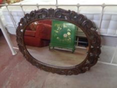 An Edwardian carved oak framed mirror