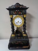 An ebonised and painted mantel clock with brass and enamelled dial on wooden base with pendulum and