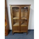 A twentieth century inlaid mahogany double door display cabinet with gilt brass mounts