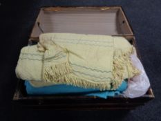 An antique wooden bound domed top trunk containing bedding and blankets