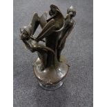 A bronze vase surmounted by two fairies