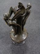 A bronze vase surmounted by two fairies