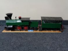 A hand built wooden model of a steam train with carriage