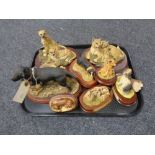 A tray of animal figures on wooden bases,