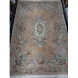 A fringed Chinese rug on peach ground,