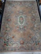 A fringed Chinese rug on peach ground,