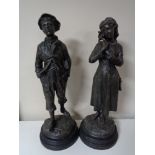 A pair of early 20th century spelter boy and girl figures on wooden bases,