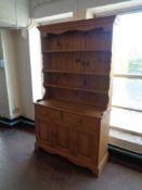 A pine triple door kitchen dresser fitted with two drawers